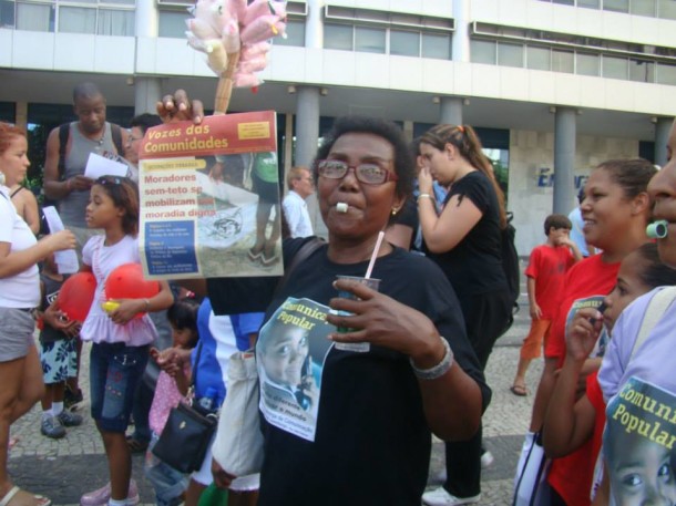 Dona Joana segurando o jornal Vozes das Comunidades